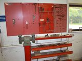a red work bench with tools on it in a garage