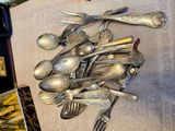 a lot of silver spoons and forks on the table
