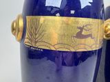 two blue vases with gold designs on them