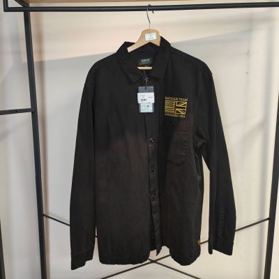 La chemise est suspendue à un portant dans un magasin de vêtements.