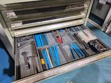 many tools in the open drawer of a machine