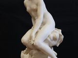 statue of a woman sitting on a rock on top of a table