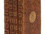 un lot de quatre livres anciens empilés les uns sur les autres