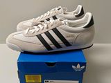 baskets adidas blanches et noires dans une boîte bleue