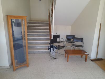 a room with a table, chairs, and stairs in it