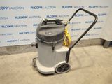 the vacuum is sitting on the floor in front of the wall