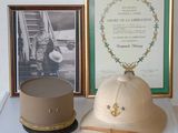 a hat on a table next to a picture of a soldier