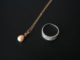 a close up of a ring and a necklace on a black surface