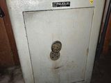une vieille porte de coffre-fort dans un garage avec un panier dessus