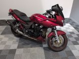une moto rouge garée dans une pièce au sol à carreaux