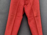 un pantalon rouge suspendu à un cintre accroché au mur