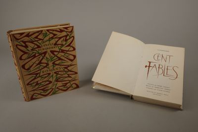 un livre ouvert posé sur une table à côté d'un livre