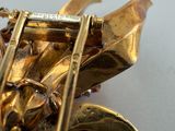 a close up of a gold saxophone with a white background