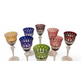 six multicolored wine glasses in a circle on a white surface
