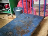 a blue metal bed frame on the floor in a room