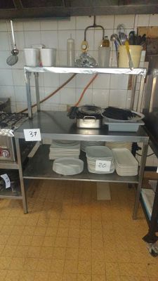 a kitchen with a stove, sink, and shelves with pots and pans on it