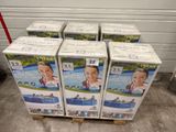 six cartons de couches pour bébés empilés sur une palette dans un entrepôt