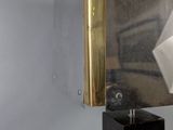 a mirror on the wall in a bathroom with a tissue dispenser attached to it