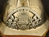 a silver fireman ' s helmet with a crest on it