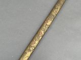 an old brass pen with a floral design on it