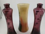 three different colored vases sitting next to each other on a white surface
