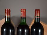 three bottles of wine sit in a wooden box on a table
