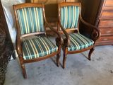 two wooden chairs with striped upholstered cushions in a room