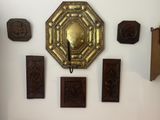 a clock on the wall in a room with many pieces of art