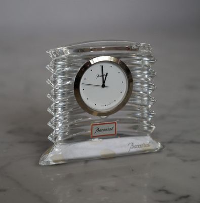 une horloge transparente posée sur une table en marbre