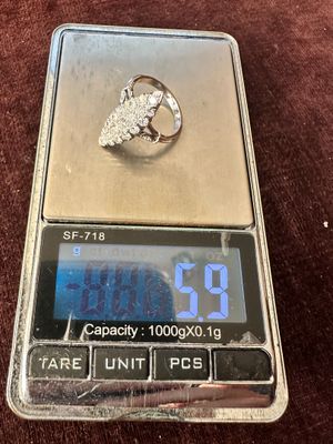 une balance en argent sur laquelle repose une bague en diamant