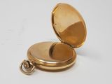 an image of a gold pocket watch on a white surface