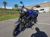 a blue motorcycle parked in a parking lot next to a building