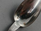 a silver spoon with a spoon handle on a table