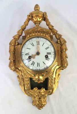 a gold clock that is hanging on the wall