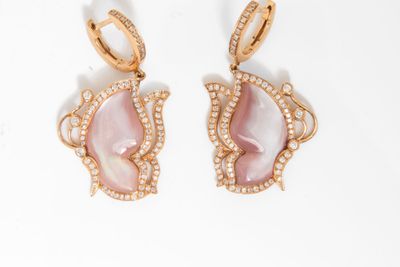 Les boucles d'oreilles en nacre rose sont ornées de diamants