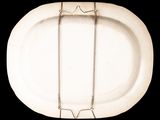 a white plate with a metal handle on a black background