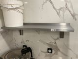 a bucket on the shelf above the stove in the kitchen