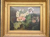 une peinture à l'huile représentant des fleurs, dans un cadre doré, accrochée à un mur bleu