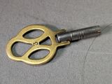 a gold key with a black handle on a table