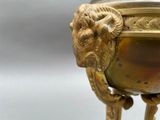 a gold vase with a lion head on it
