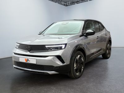 a silver car is parked in a large room with a black floor