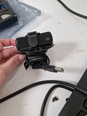 a person holding a camera that is plugged into a laptop