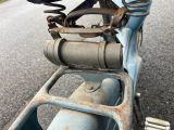 a blue scooter parked on the side of the road