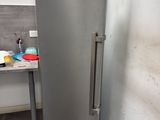 a silver refrigerator in the corner of a kitchen