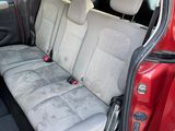 the back seats of a red car are empty in a parking lot