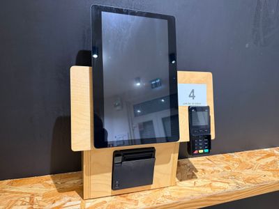 une tablette et un téléphone posés sur une étagère en bois