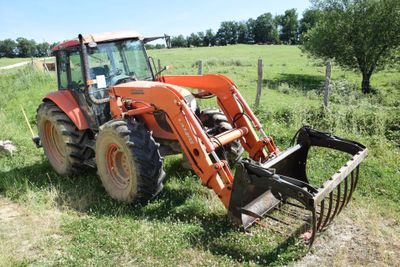 a tractor that is sitting in the grass in the field
