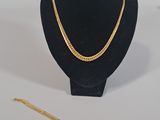 two necklaces and a bracelet on a mannequin stand