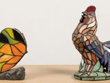 two figurines of a rooster and a butterfly on a table
