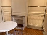 une table et des chaises blanches dans une pièce avec une cheminée